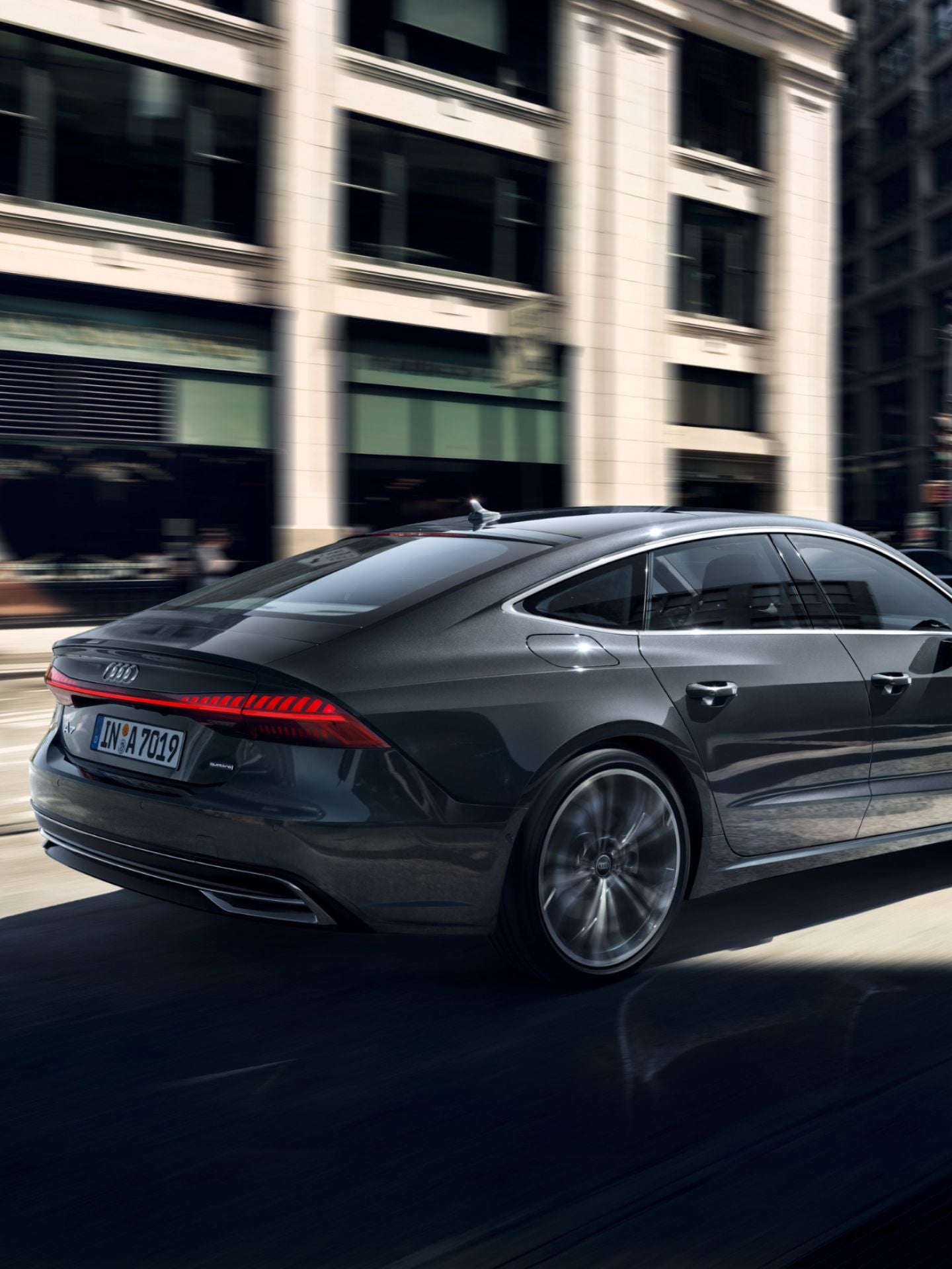 Audi sedan in motion on a city street, exhibiting speed with a blurred background.