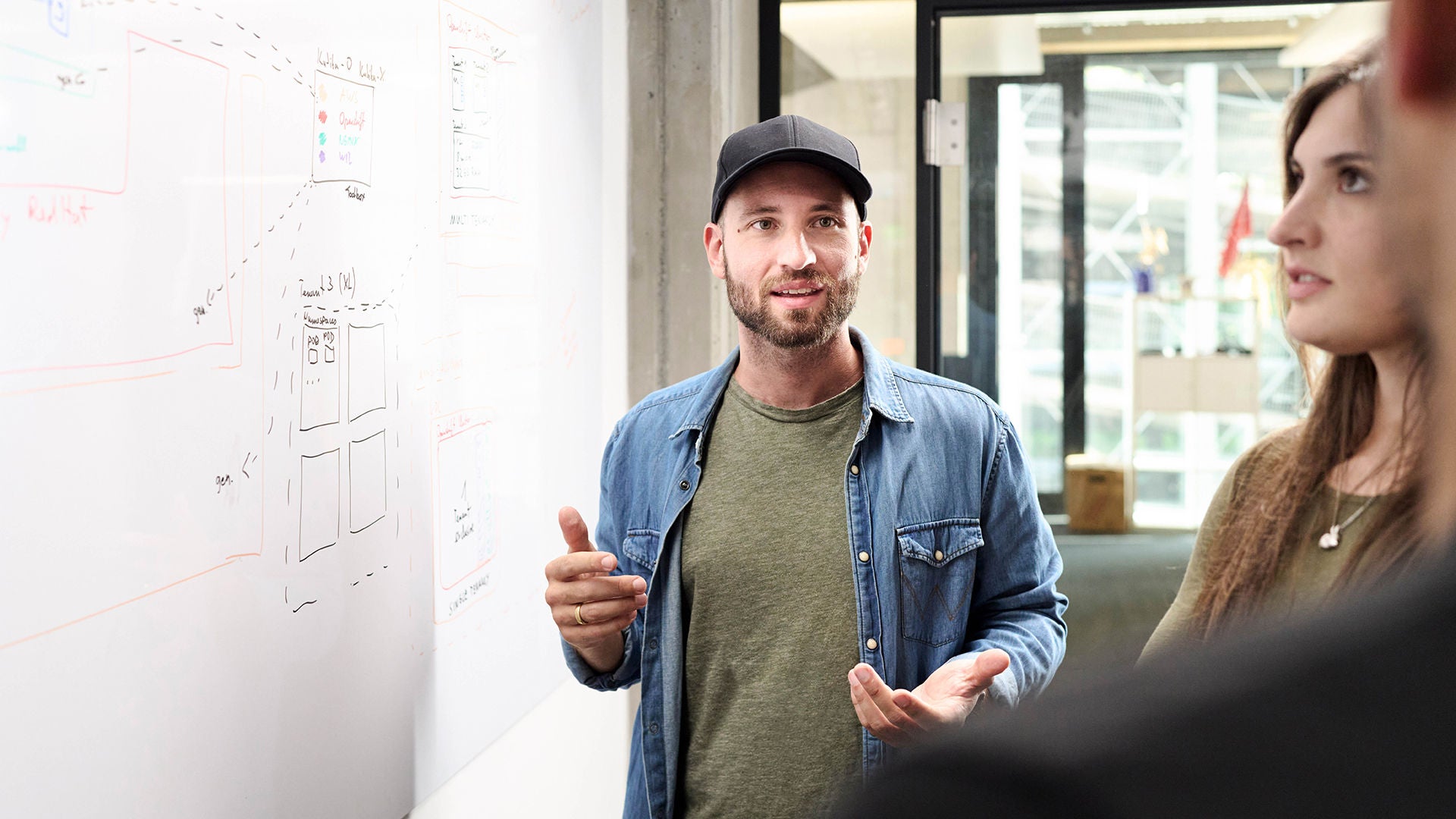 Sebastian Kister unterhält sich mit Kollegen und steht neben einem Sideboard mit Notizen darauf