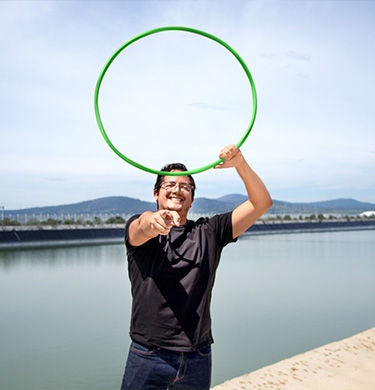Employee with a green tire standing in front of a body of water