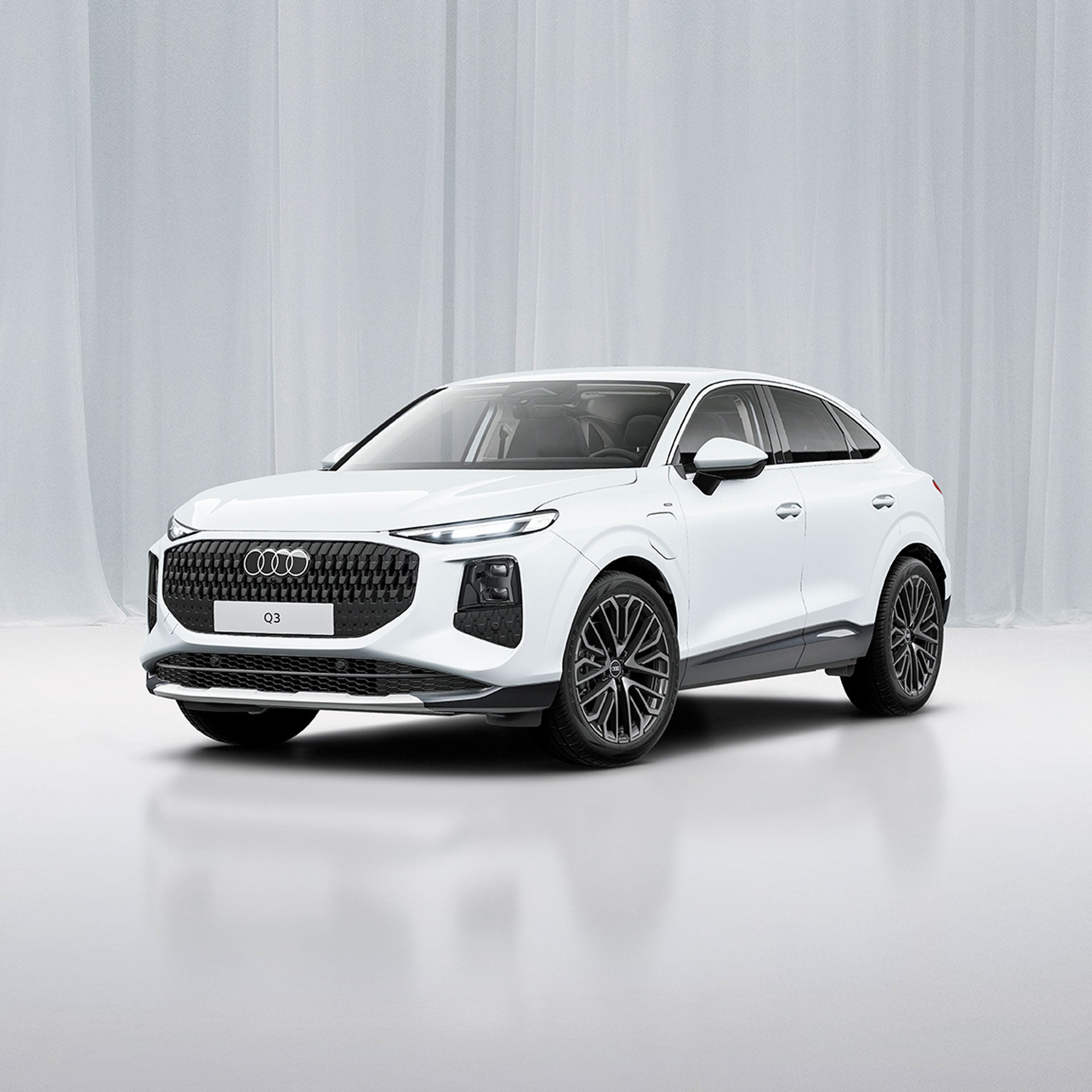 Weißer Audi Q3 Sportback e-hybrid vor einem modernen Gebäude in 3/4 Ansicht