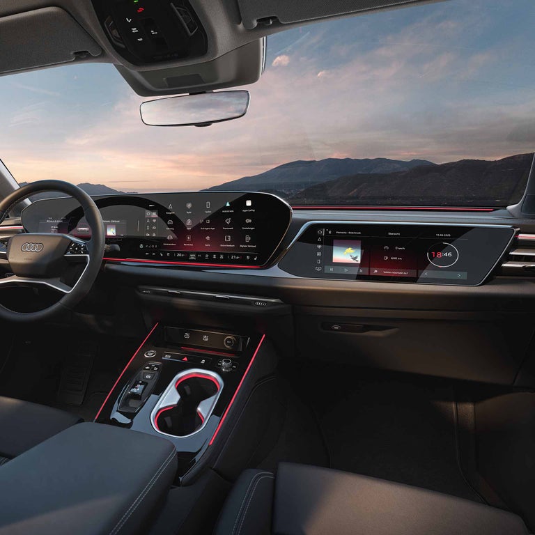 Blick in ein modernes Fahrzeugcockpit mit zwei großen, digitalen Bildschirmen.