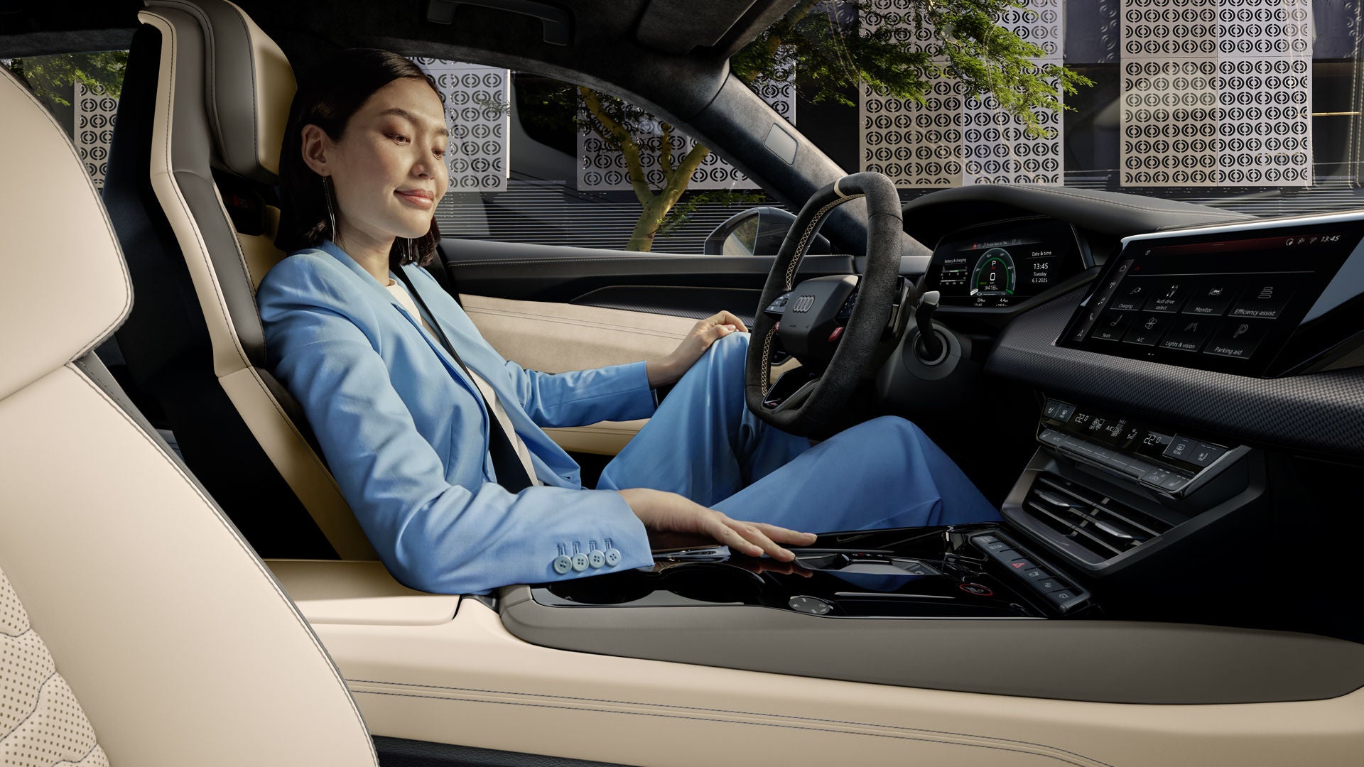 Een vrouw in een blauw pak zit comfortabel in de Audi RS e-tron GT, die is voorzien van een lichtgekleurd lederen interieur en digitale displays.