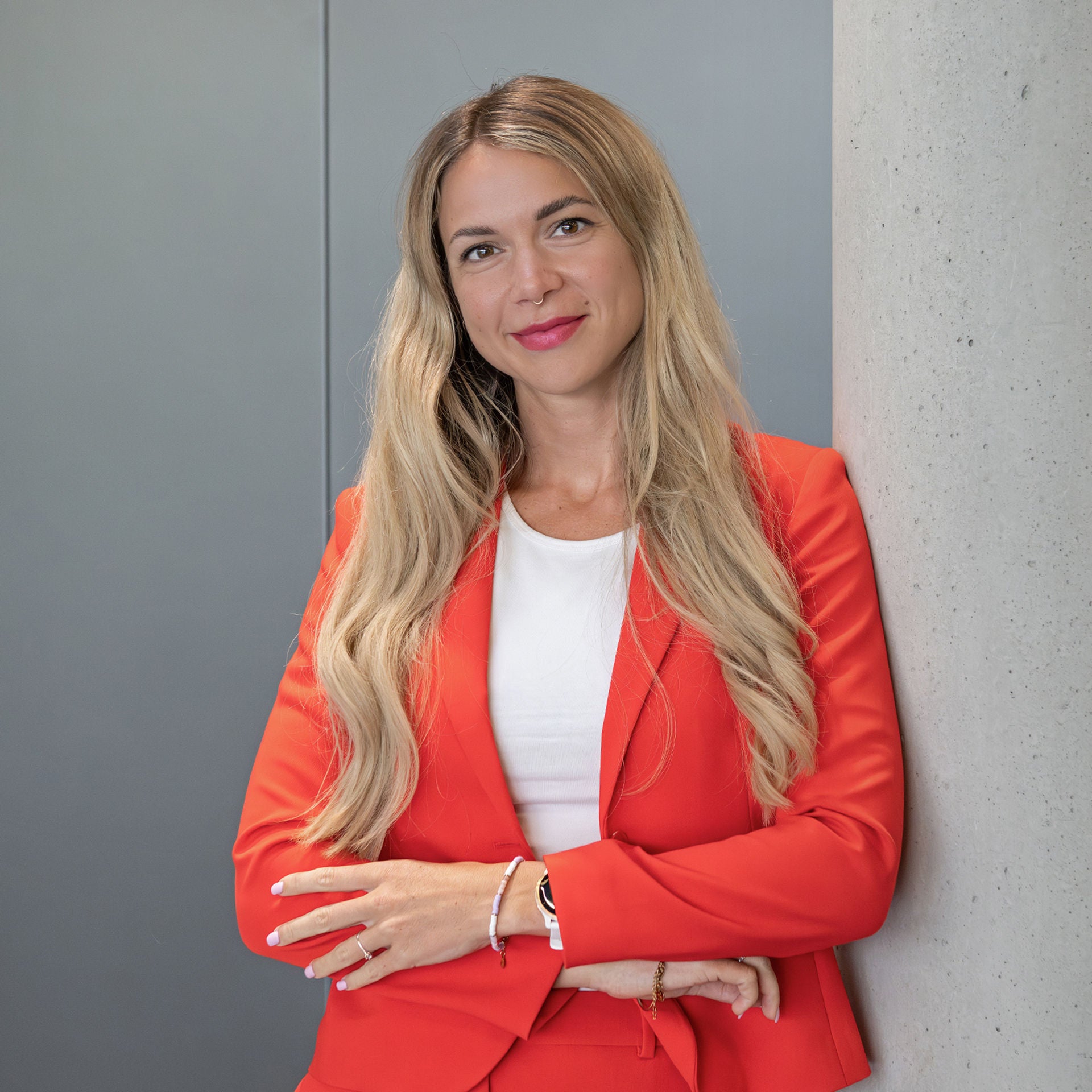 Caro Ribes Navarro smiles at the camera while leaning against a concrete wall