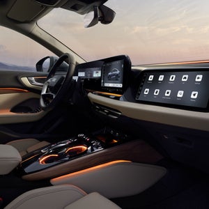 A view into the cockpit of the A5 Saloon from the passenger side. The interior is bathed in orange ambient lighting.