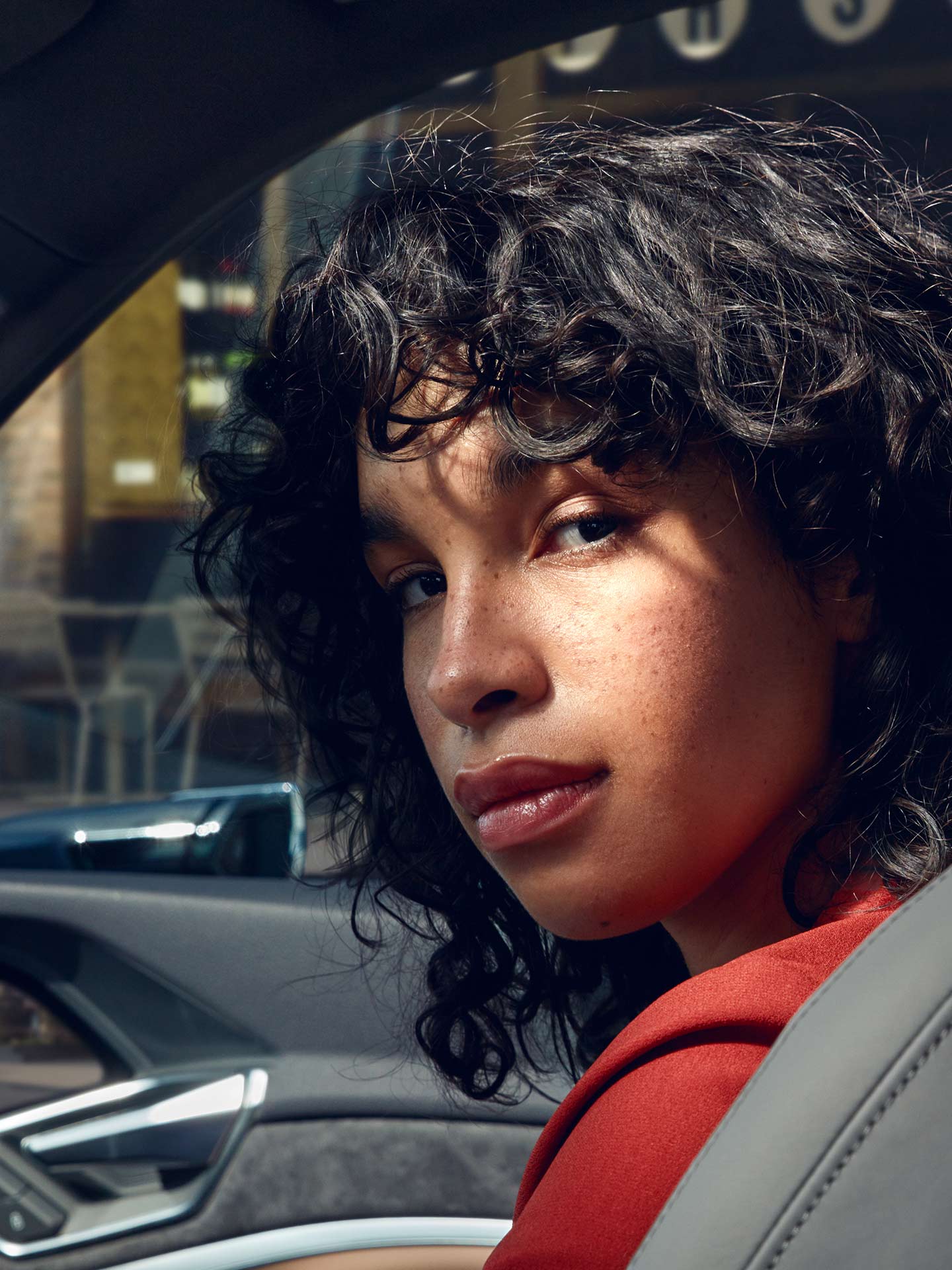 Woman looks back over her shoulder from the passenger seat of an Audi e-tron Sportback