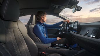 Zentrales Display im Audi zeigt E-Mail-Übersicht mit Betreffzeilen, daneben Klimasteuerung und Mediensystem im schwarzen Cockpit.