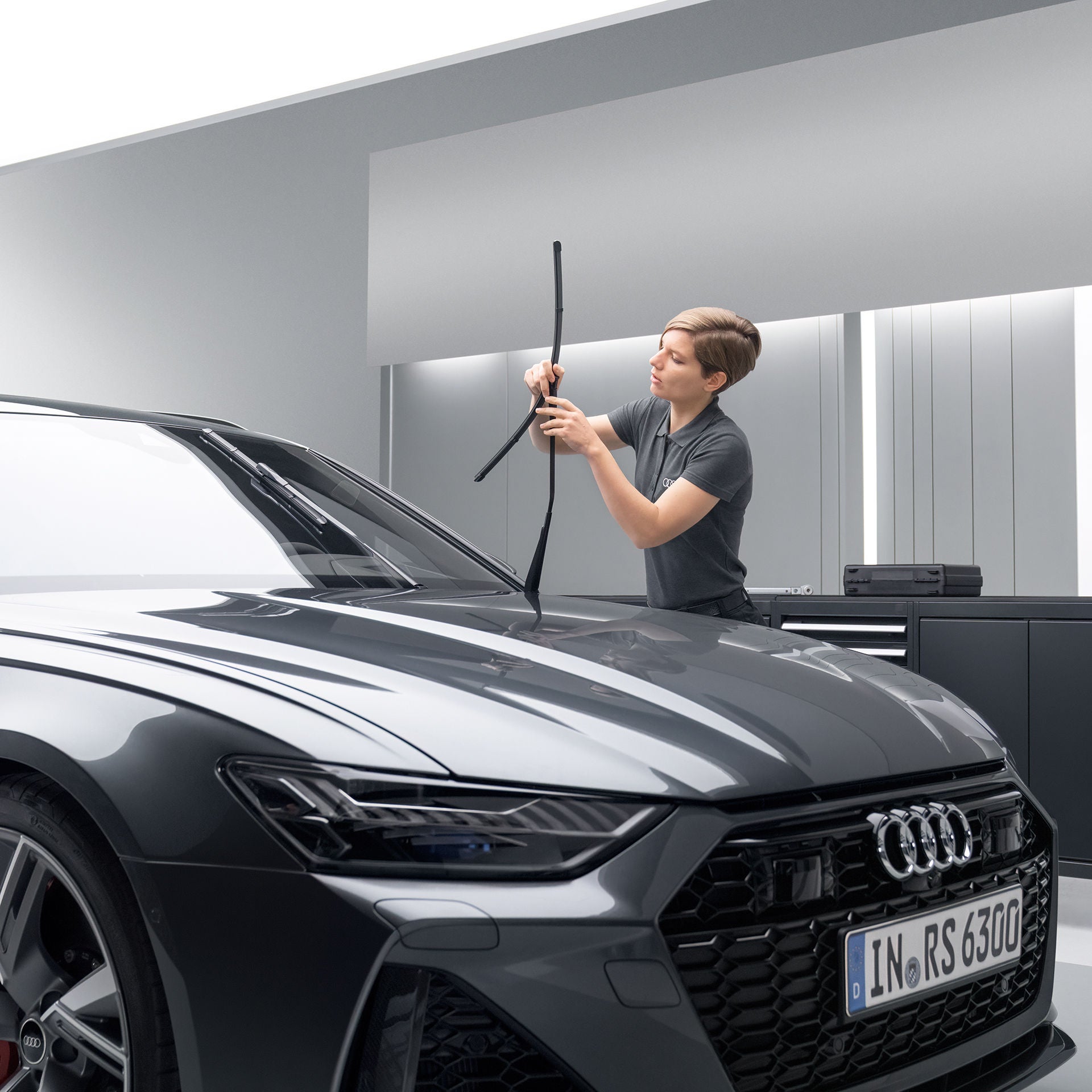 Audi servicepersonal som utför ett torkarbladsbyte på en svart Audi RS