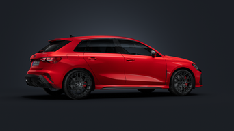Een groene Audi RS 3 Sportback staat voor een gebouw