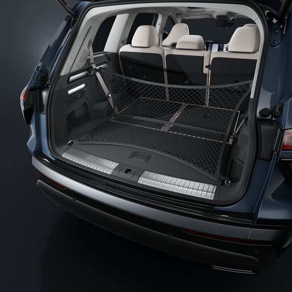 Gros plan sur le coffre ouvert du SUV Audi Q7. Au premier plan, le filet à bagages tendu.