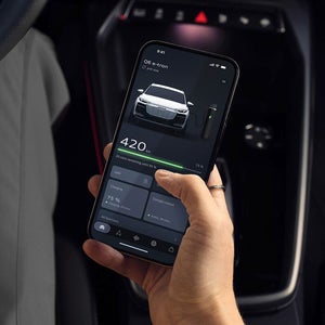 Audi Q6 SUV e-tron display shows 73% charge with 207-mile range, updated 2 hours ago. Minimalist design with open lock icon at bottom.