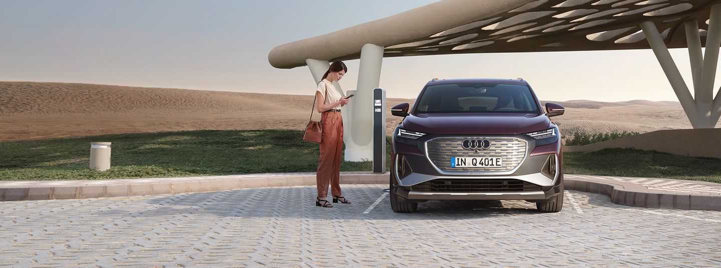 Vooraanzicht van Q4 e-tron naast een laadpaal