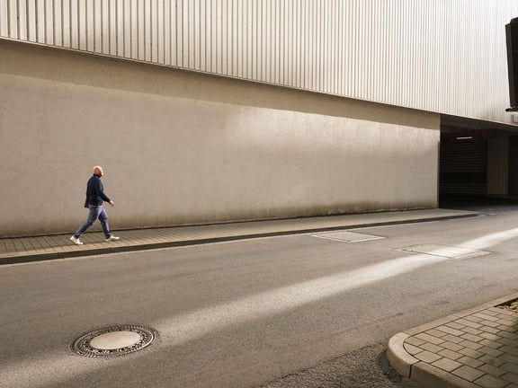 Sebastian läuft eine Straße entlang, von der Kamera weg