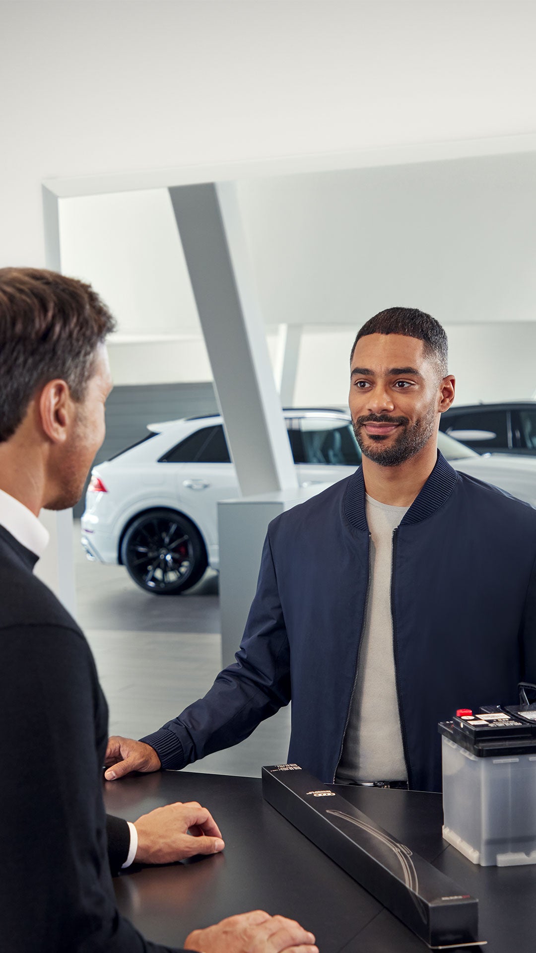 Zwei Männer stehen an einem Service Counter und unterhalten sich