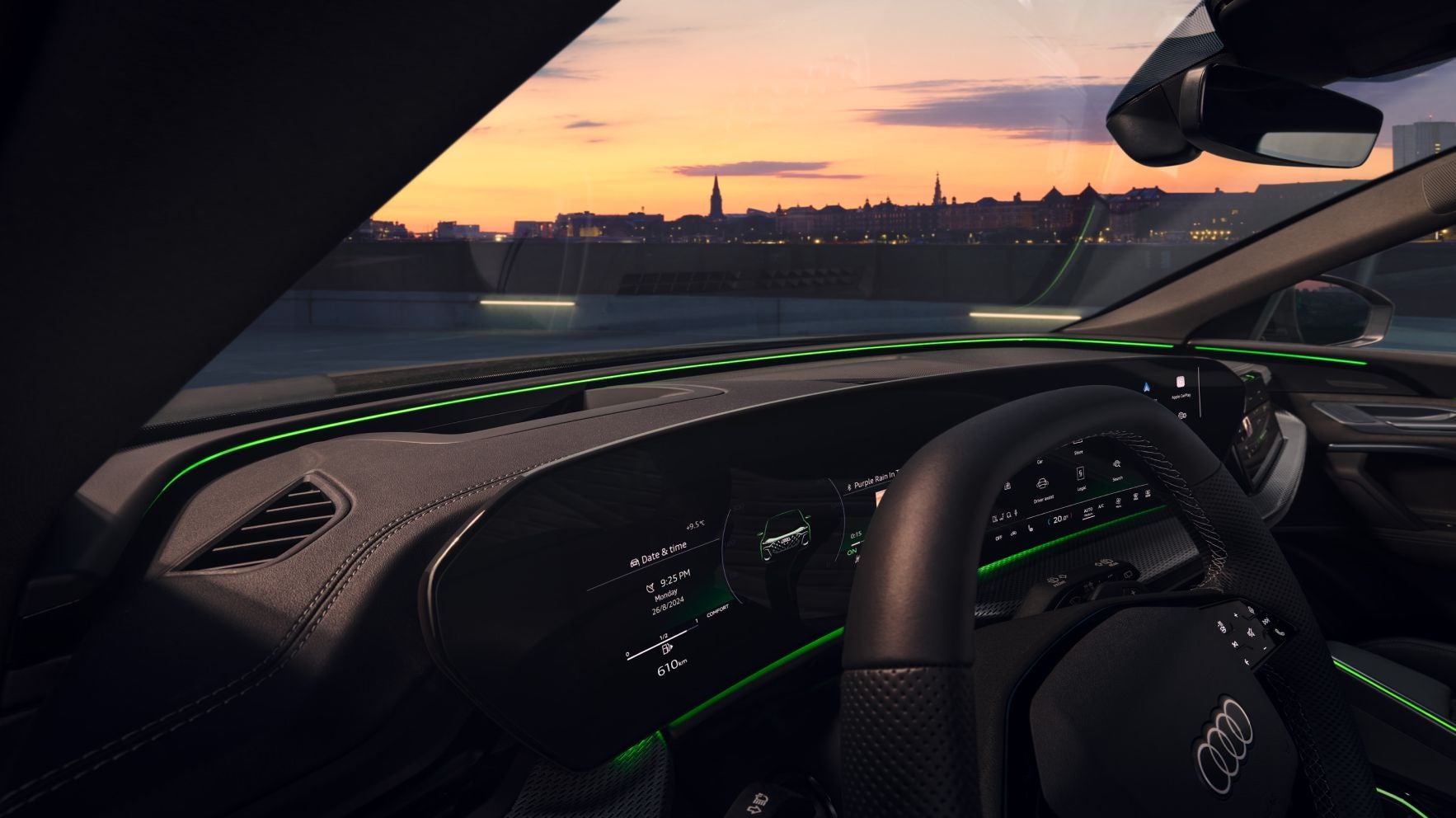 Interior view of a car with dashboard and city skyline during sunset in the background.