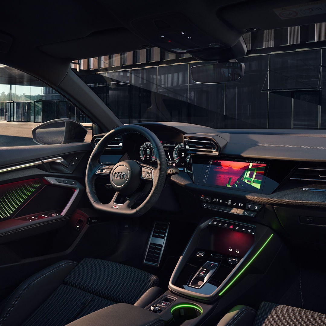 Someone is sitting in a car and holding a smartphone in their hand