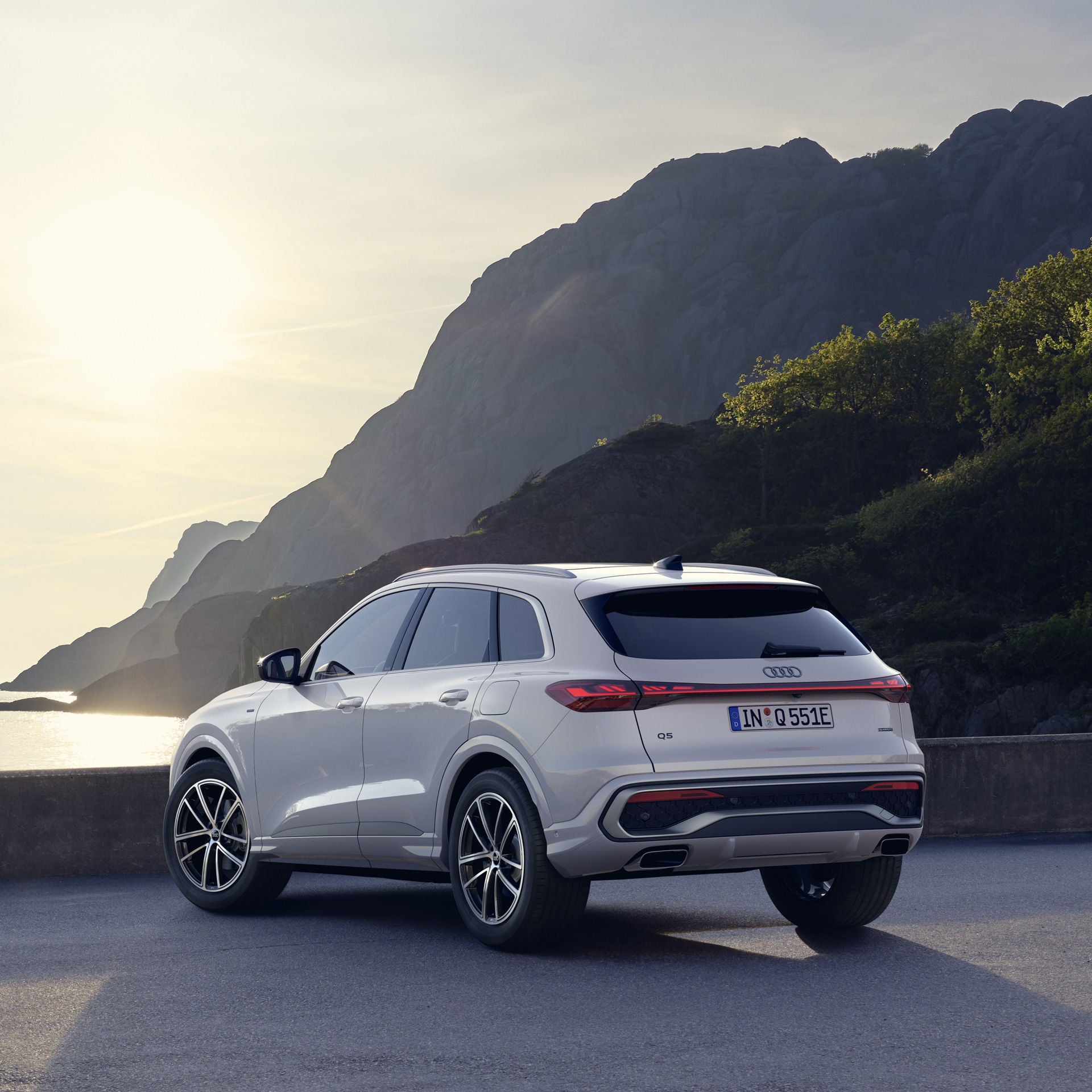 White Audi Q5 SUV e-hybrid parked on a rocky coastline