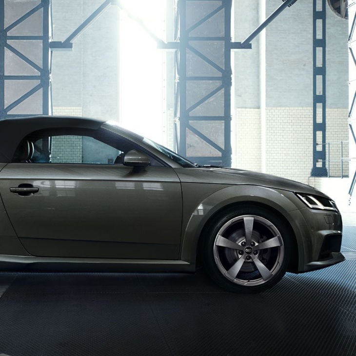 Side view of soft-top Audi TT Roadster in an empty warehouse.