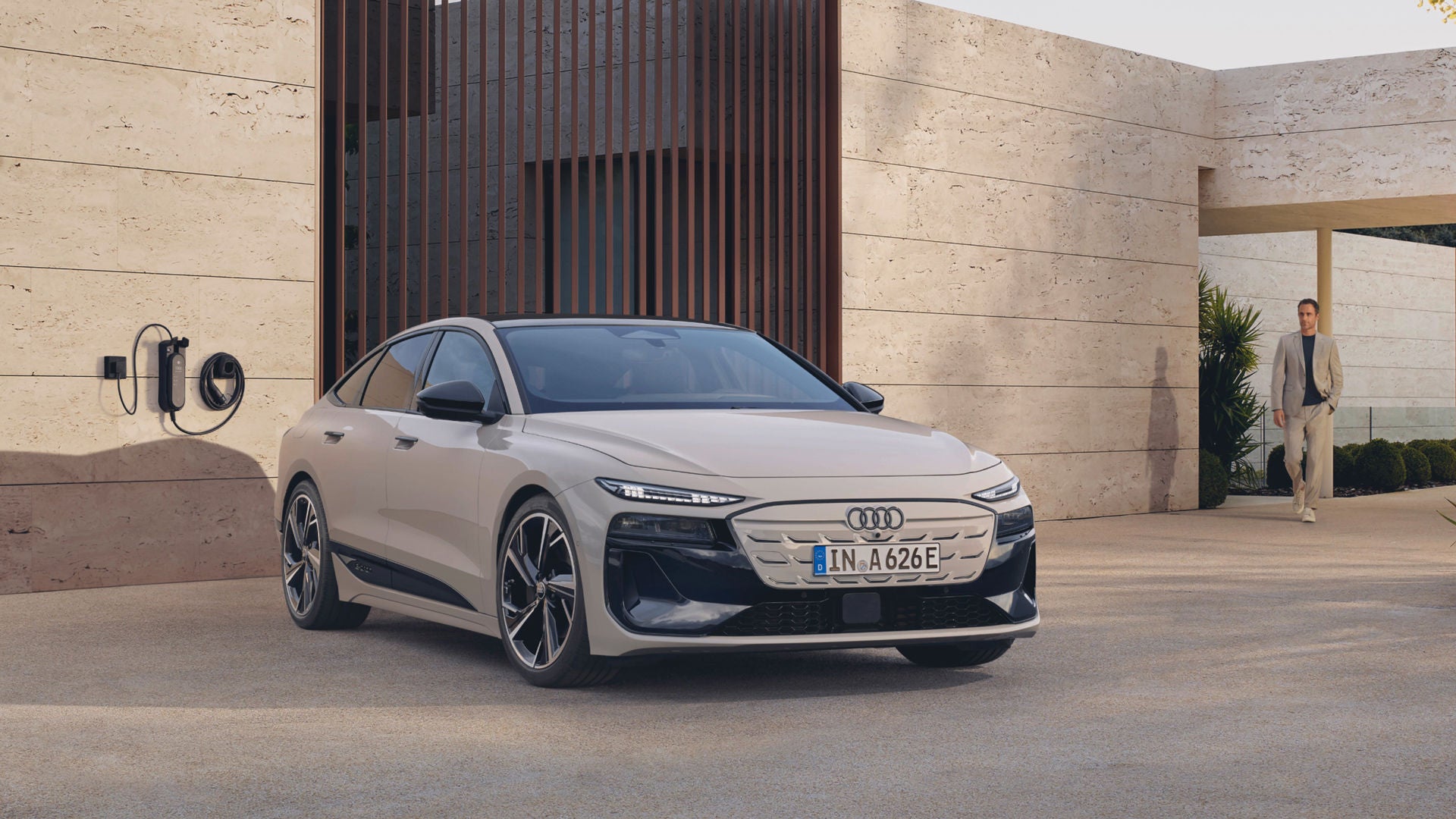 An Audi electric car parked near a charging station outside a modern building.