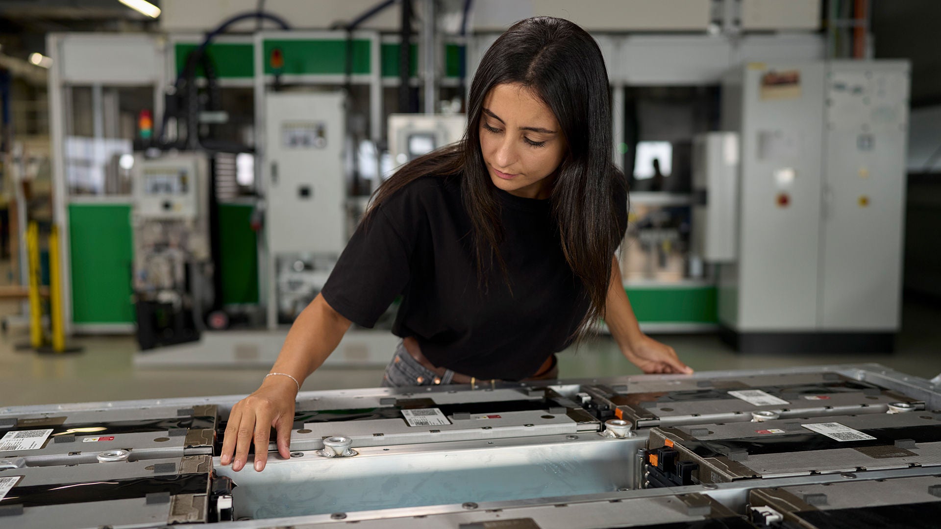 Aylin Reyhan is busy with a high-voltage battery from Audi standing in front of her