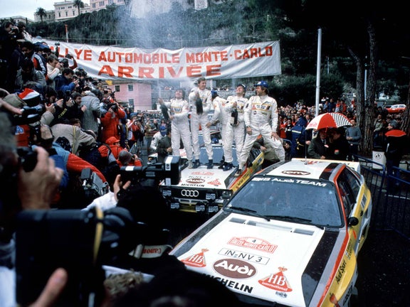 A picture showing the Audi Sport team celebrating the podium sweep victory at the 1984 Monte Carlo Rally.