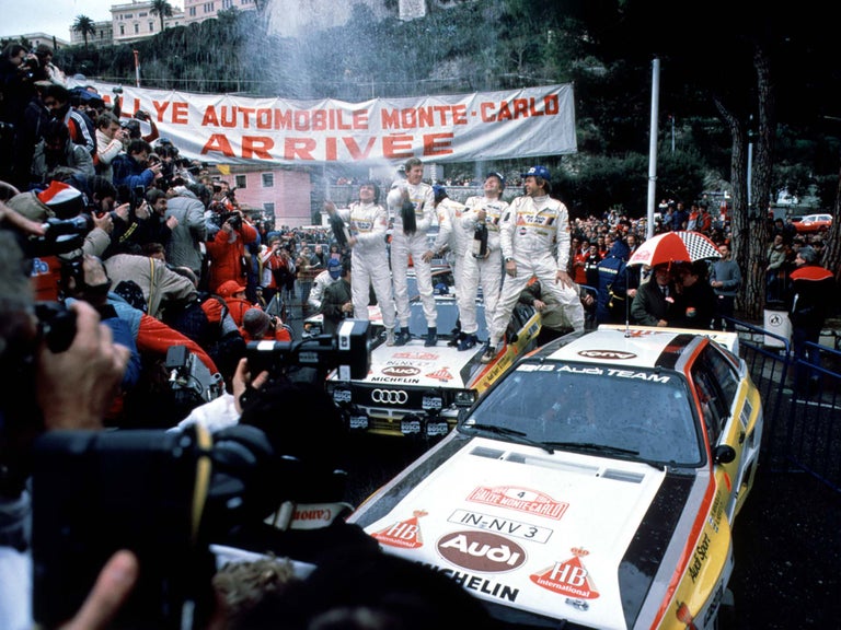 A picture showing the Audi Sport team celebrating the podium sweep victory at the 1984 Monte Carlo Rally.