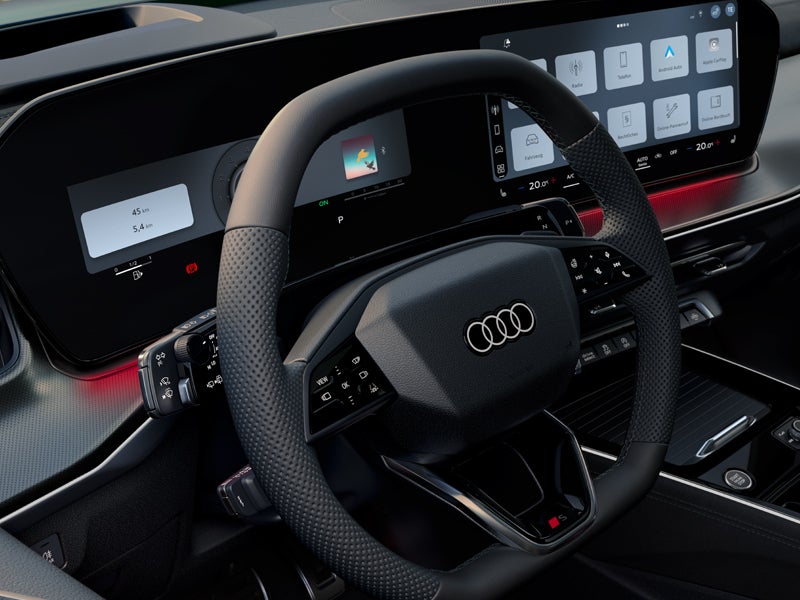 Blick von vorne auf das Lenkrad, Mittelkonsole und digitale Displays.