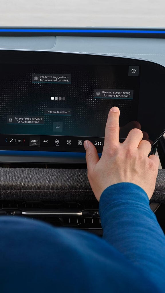 An Audi vehicle parked on a roadside with mountainous terrain in the background