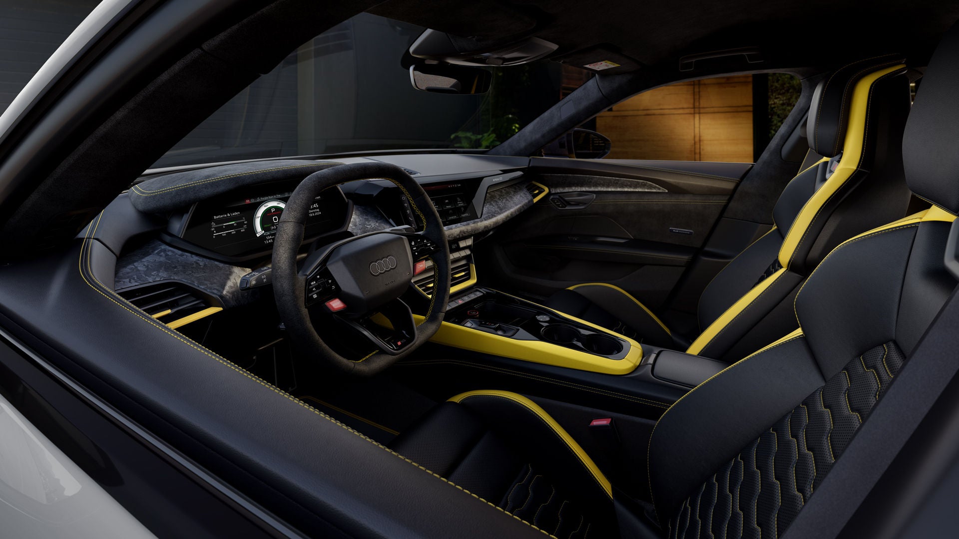 Innenraum eines grauen Audi RS e-tron GT performance mit schwarzem Leder, gelben Akzenten und digitalem Cockpit, aufgenommen durch die offene Tür.