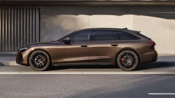 Der A6 Avant steht im Seitenprofil in einer Parkbucht vor der Fassade eines Gebäudes.