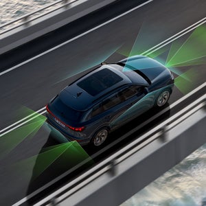 Der Q6 SUV e-tron von schräg oben. Vom Heck und der Front aus unterteilen grüne und blaue Vektoren die Flächen hinter und vor dem Fahrzeug.