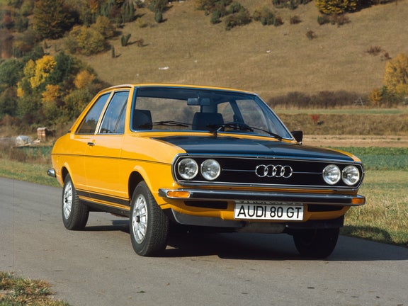 Front side view of an Audi 80 GT sports package in orange in front of a hill