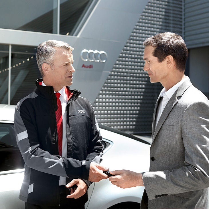 An Audi owner passing his keys to an Audi employee for a service appointment.