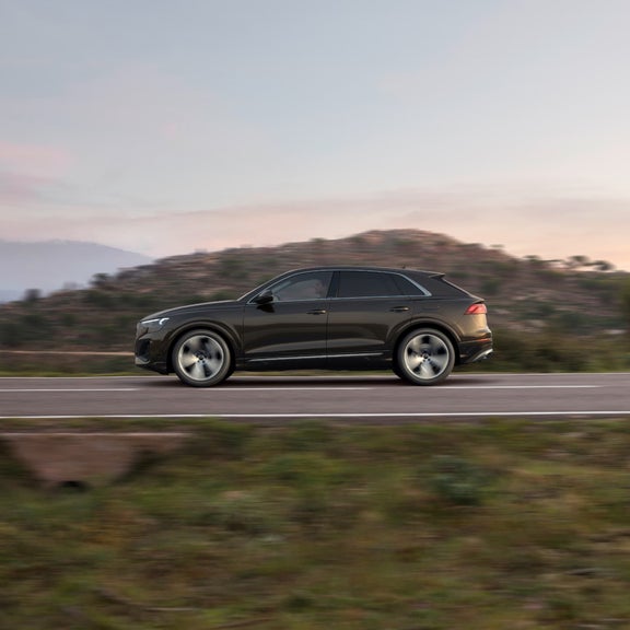 Audi Q8 tfsi e moving along road.