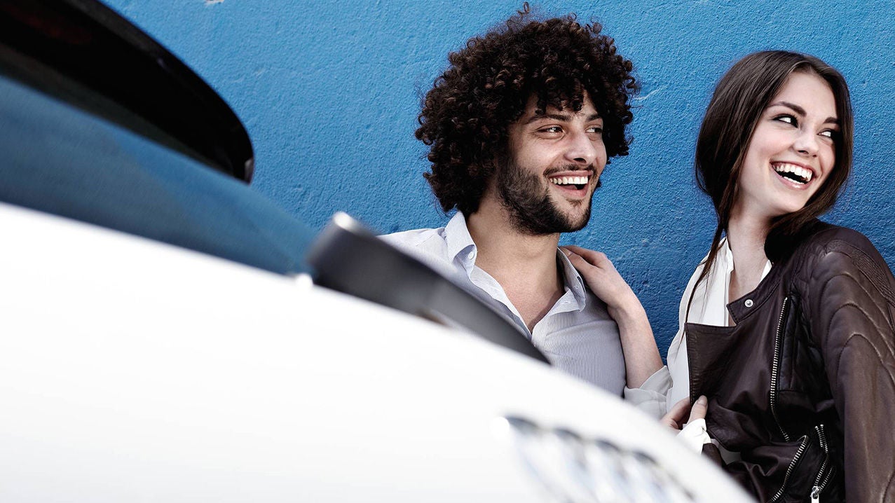 Persone sorridenti dietro a un’Audi