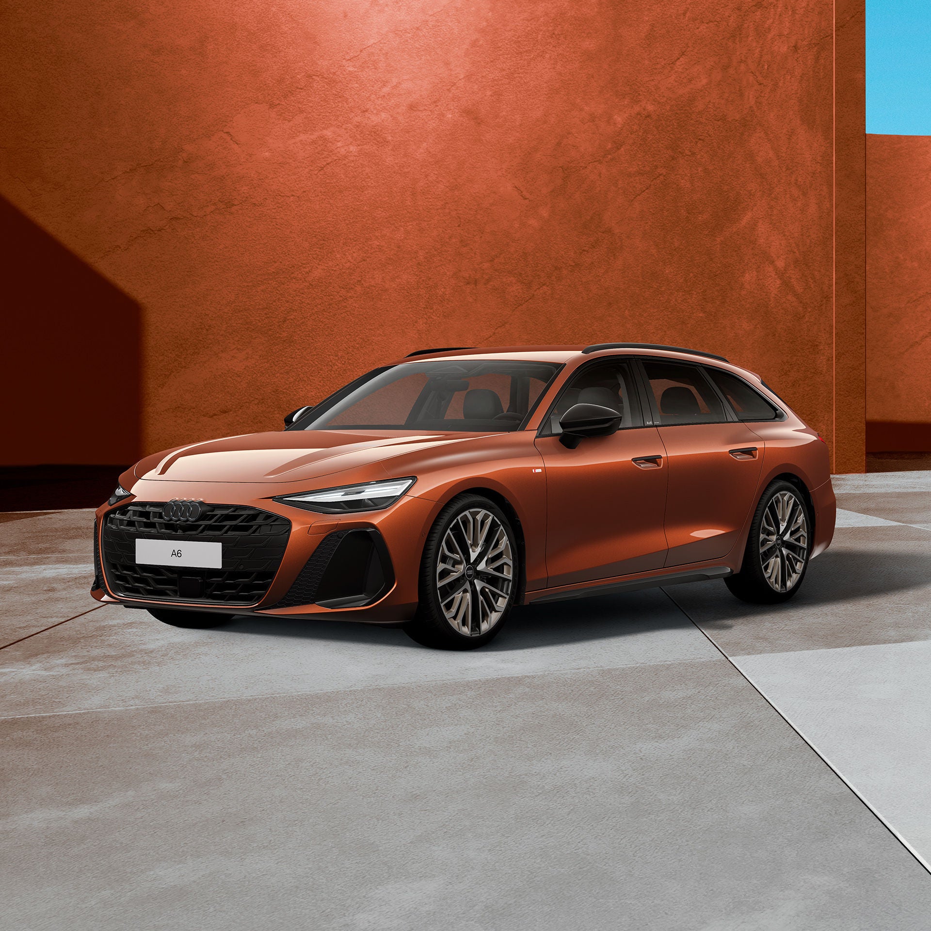 Braunes Kombi-Auto in schräger Frontansicht mit sportlichem Design, großen Felgen, vor hellem Studiohintergrund.