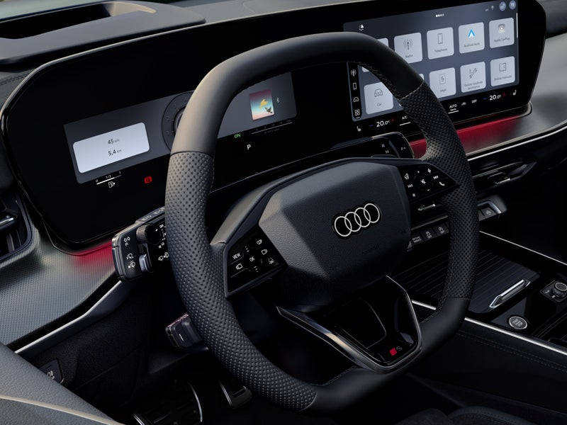 Front view of the steering wheel, center console, and digital displays.