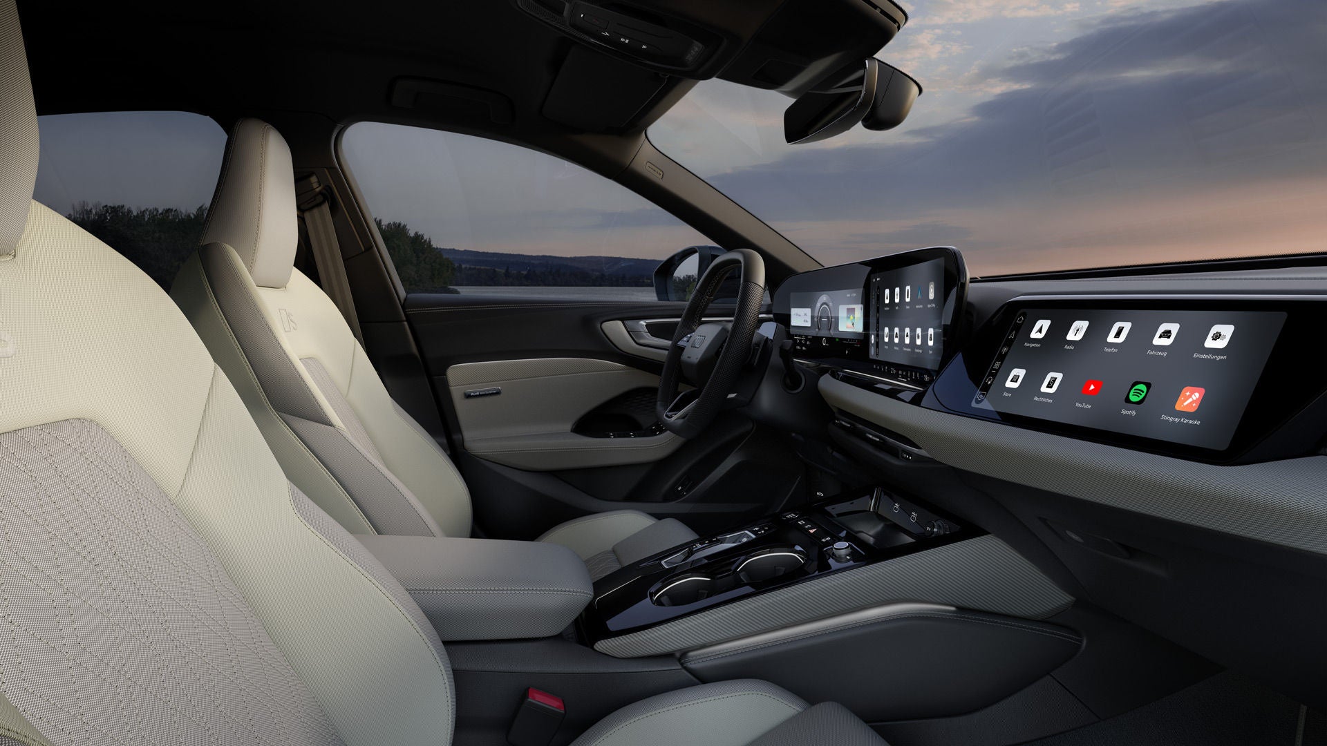 Blick auf das Cockpit der A5 Limousine e-hybrid von der Beifahrerseite. Zu sehen sind Lenkrad, Mittelkonsole, die Panoramadisplays sowie die Vordersitze mit Bezügen in Stoff in Hellgrau/Ingwerweiß mit Rautensteppung und Kontrastnähten in Diamantsilber.