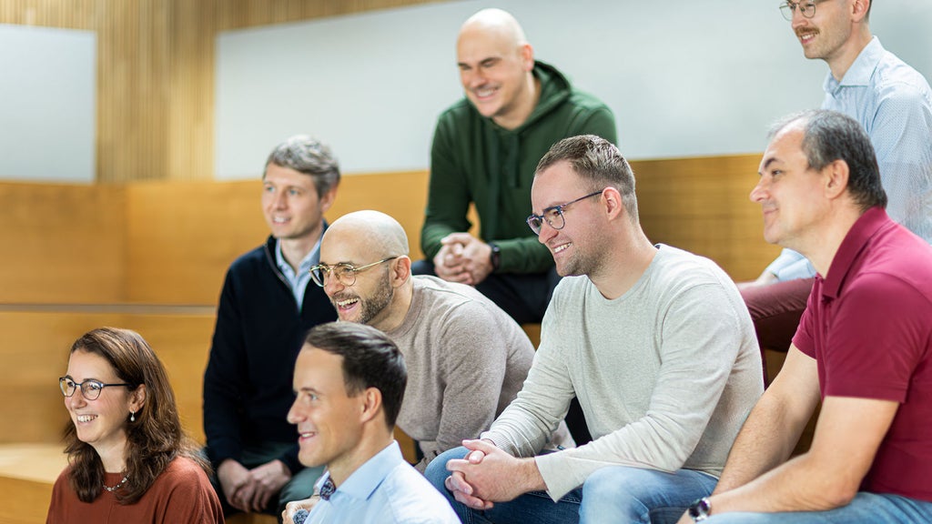 Mario de Felice sitzt mit seinen Kollegen auf einer Treppe