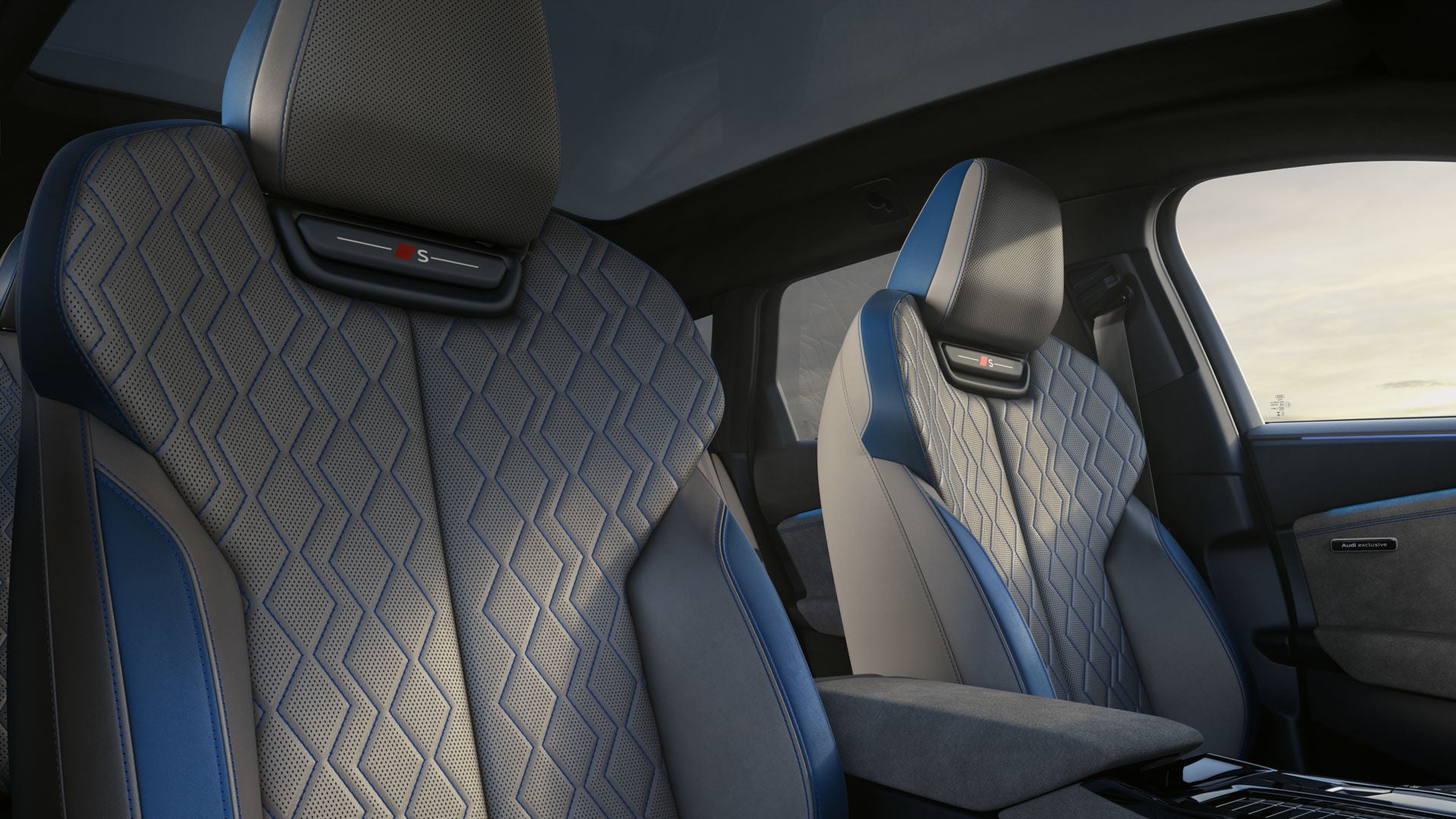 The front two seats of the S6 Avant e-tron as seen from the passenger window. The interior features the Jet Grey/Ocean Blue design package.