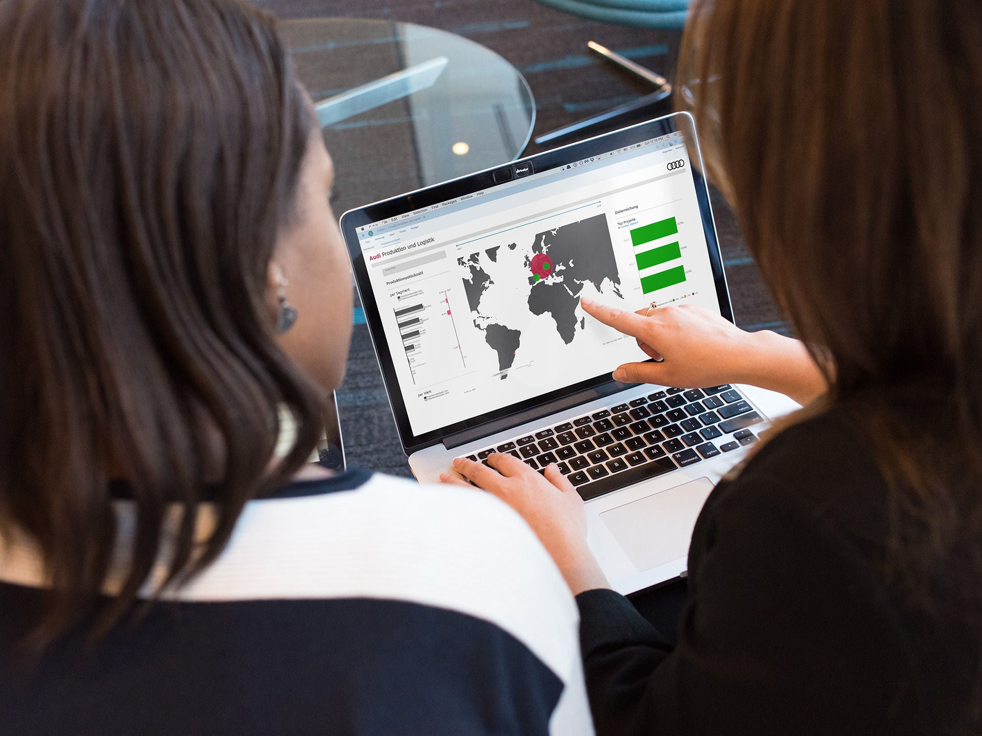 Two people looking at a laptop screen. One person points to a specific region on the screen.