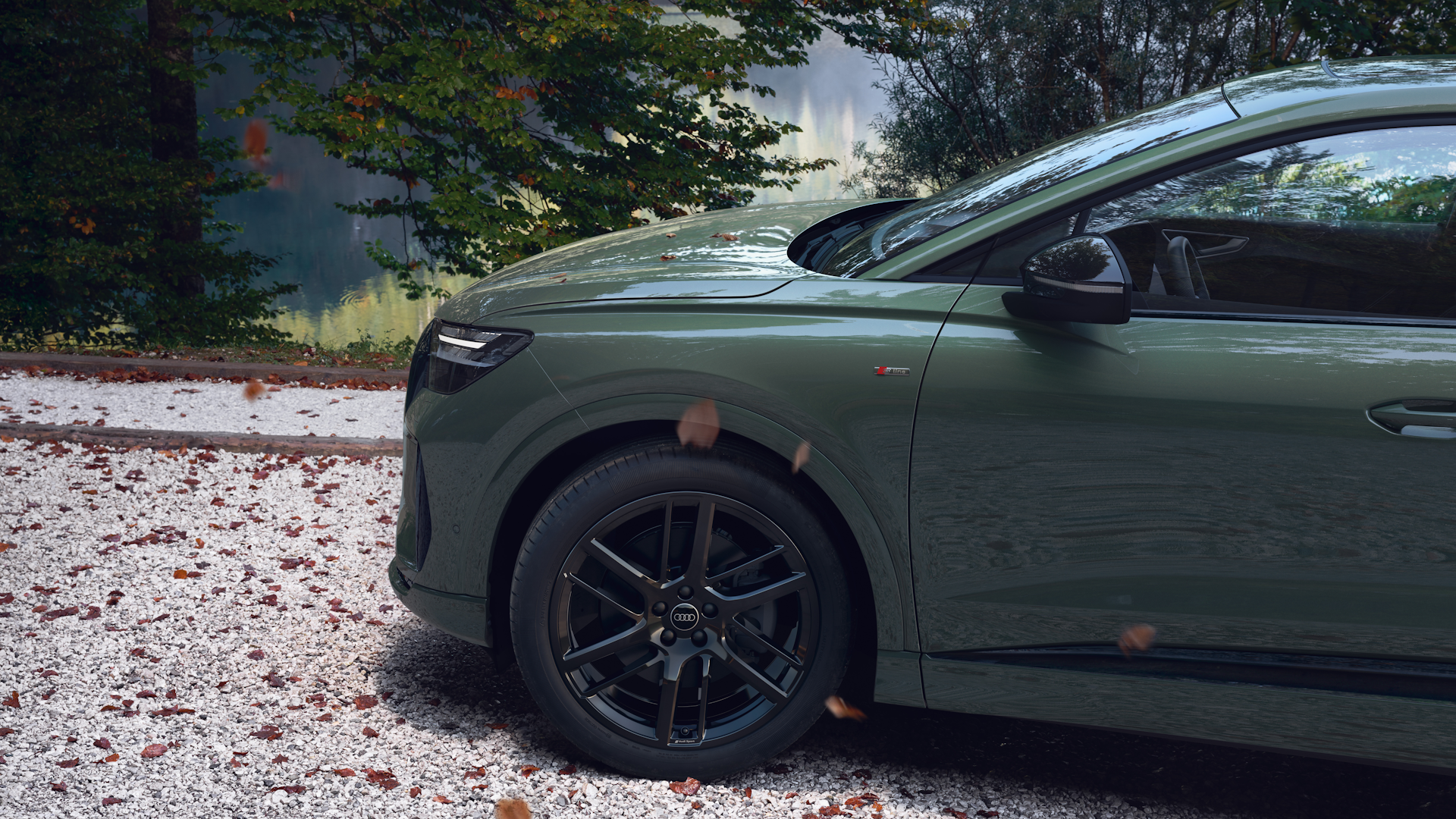 En grøn Q4 Sportback parkeret på nogle sten