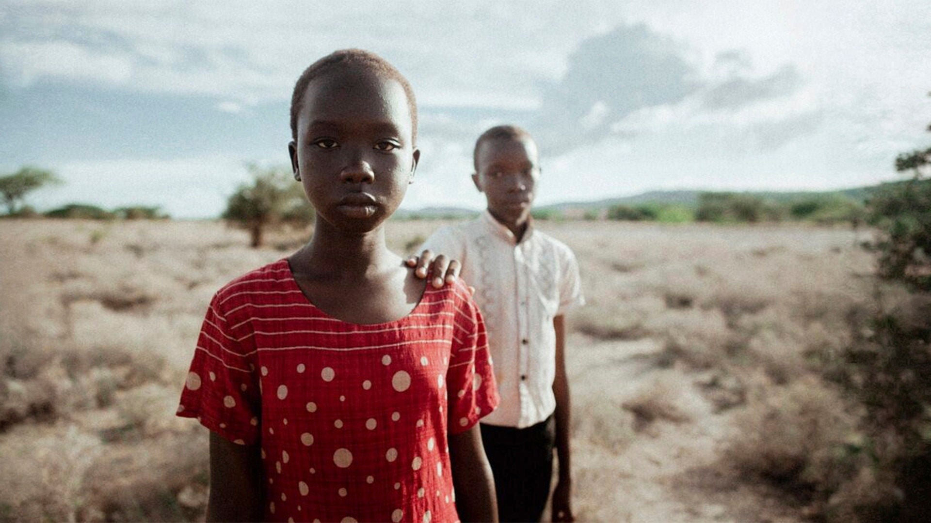 Die junge Nawi steht mit entschlossenem Blick neben ihrem Bruder in der Wüste.
