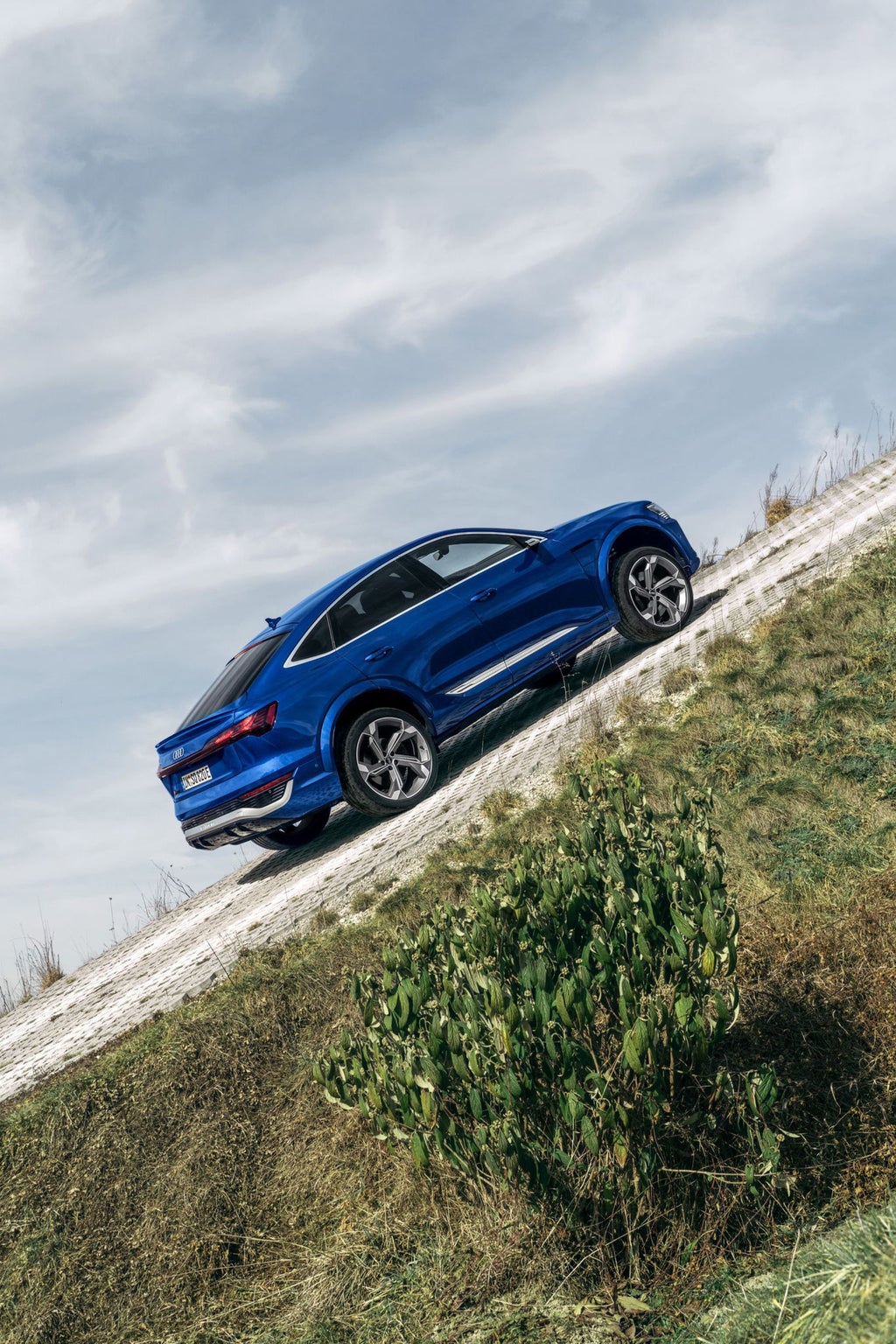 Audi SQ8 Sportback e-tron sett fra siden i en oppoverbakke.