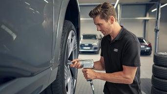 Mann repariert einen Reifen im Autohaus