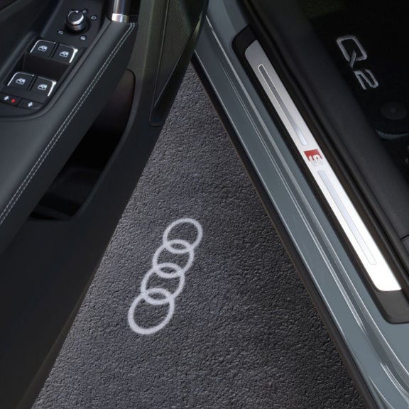 The interior of an Audi Q2 vehicle with passenger side door open, the focus on the door controls