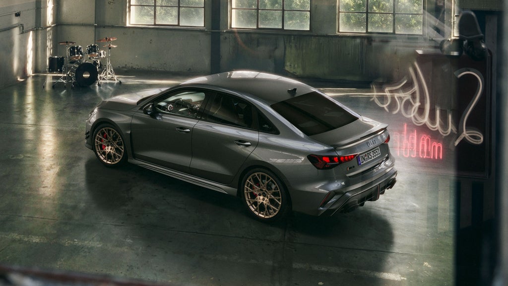 Das Sondermodell RS 3 competition limited schräg von oben in einer Werkstatthalle stehend. Im Hintergrund ein Schlagzeug.