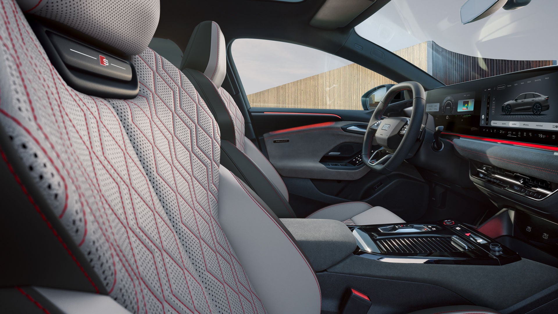 Zicht in het cockpit van de Audi S6 Sportback e-tron van de passagierszijde. De zetels zijn bekleed in leder in diamantzilver/jetgrijs met contrasterende stiksels in karmijnrood.