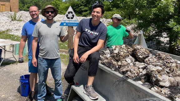 Helfer neben einem beladenen Wagen