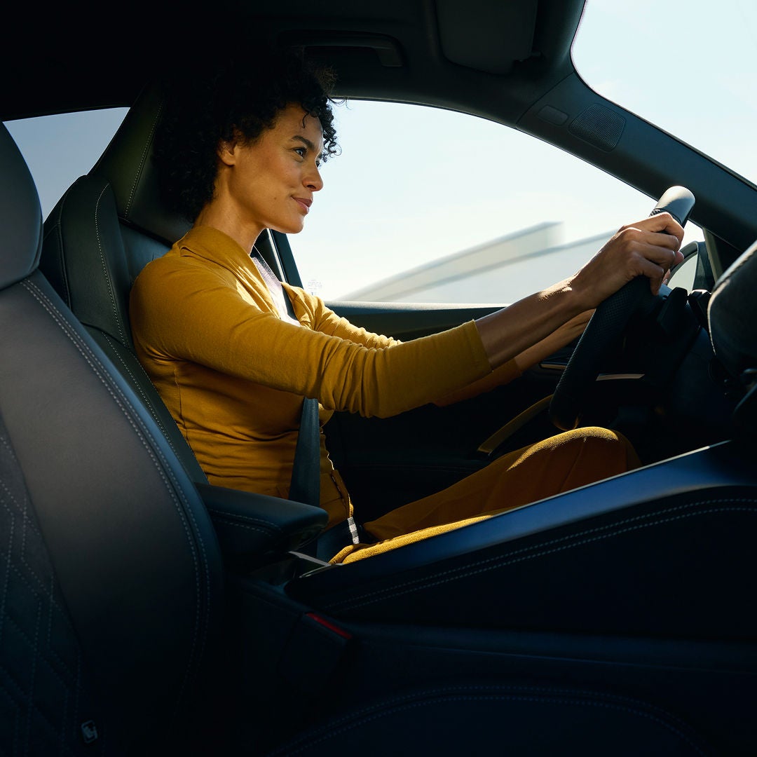 A woman driving an Audi vehicle.