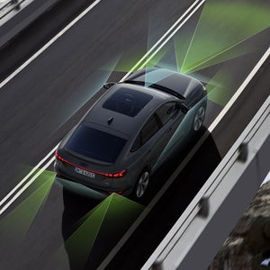 Der Q6 Sportback e-tron von schräg oben. Vom Heck und der Front aus unterteilen grüne und blaue Vektoren die Flächen hinter und vor dem Fahrzeug.